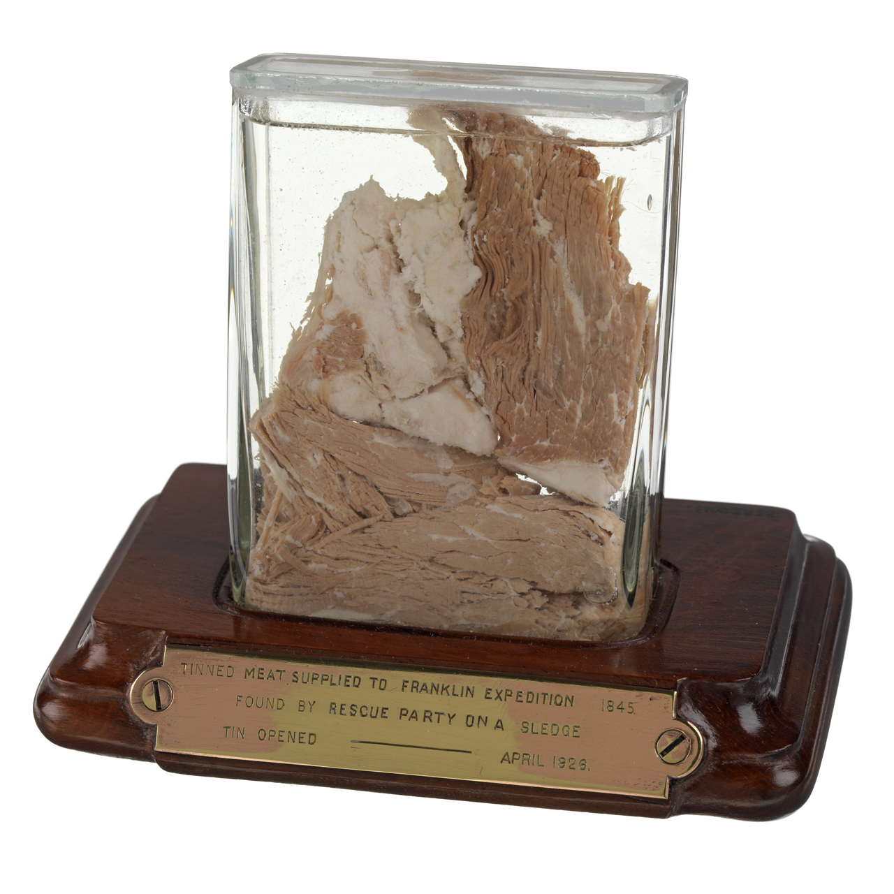 Meat sample - A relic of Sir John Franklin's last expedition 1845-8. A sample of tinned meat preserved in spirit in a rectangular glass container mounted on a mahogany base with a brass plate fixed to the front
