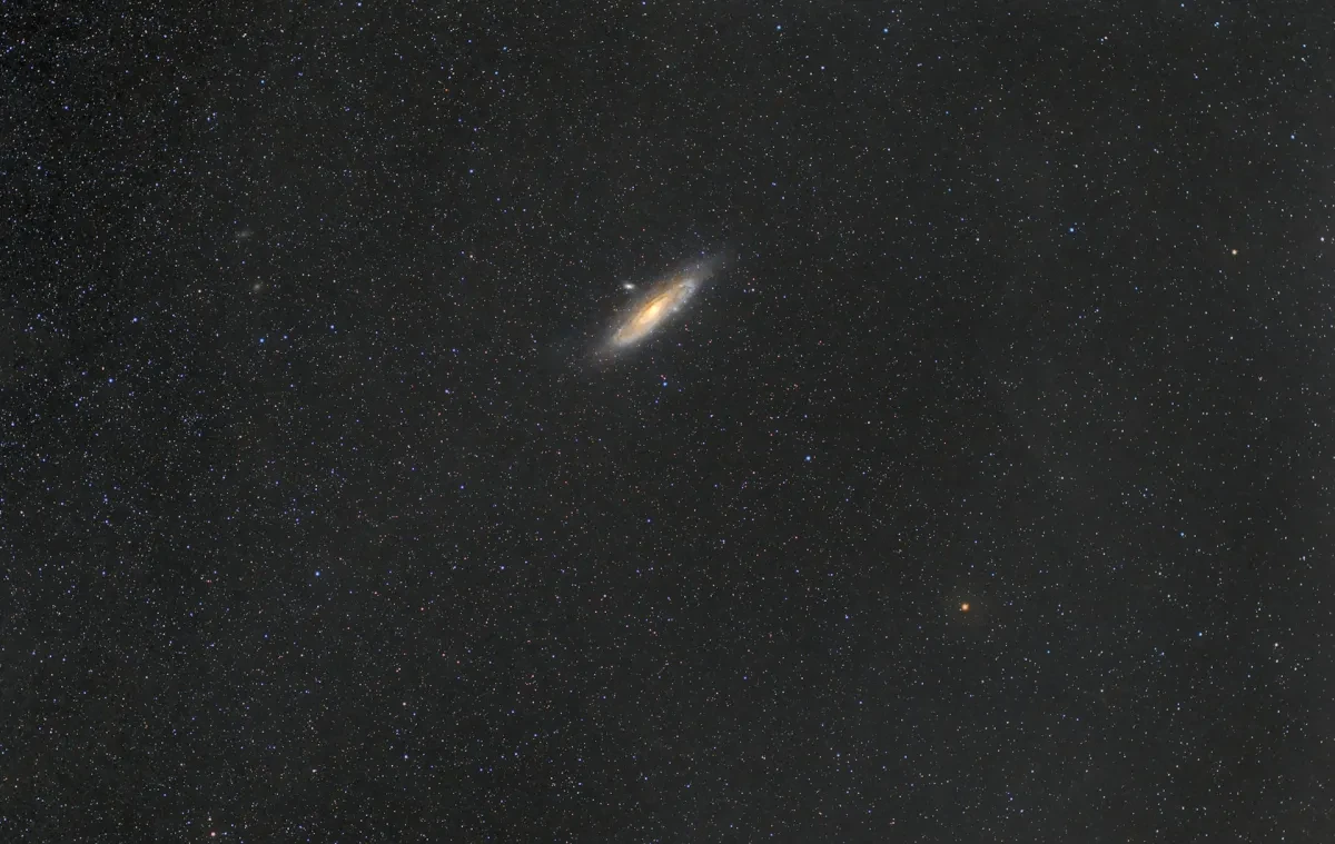 Image of dark starry night sky with a bright white oval around 3mm across which is the Andromeda Galaxy seen from a long distance