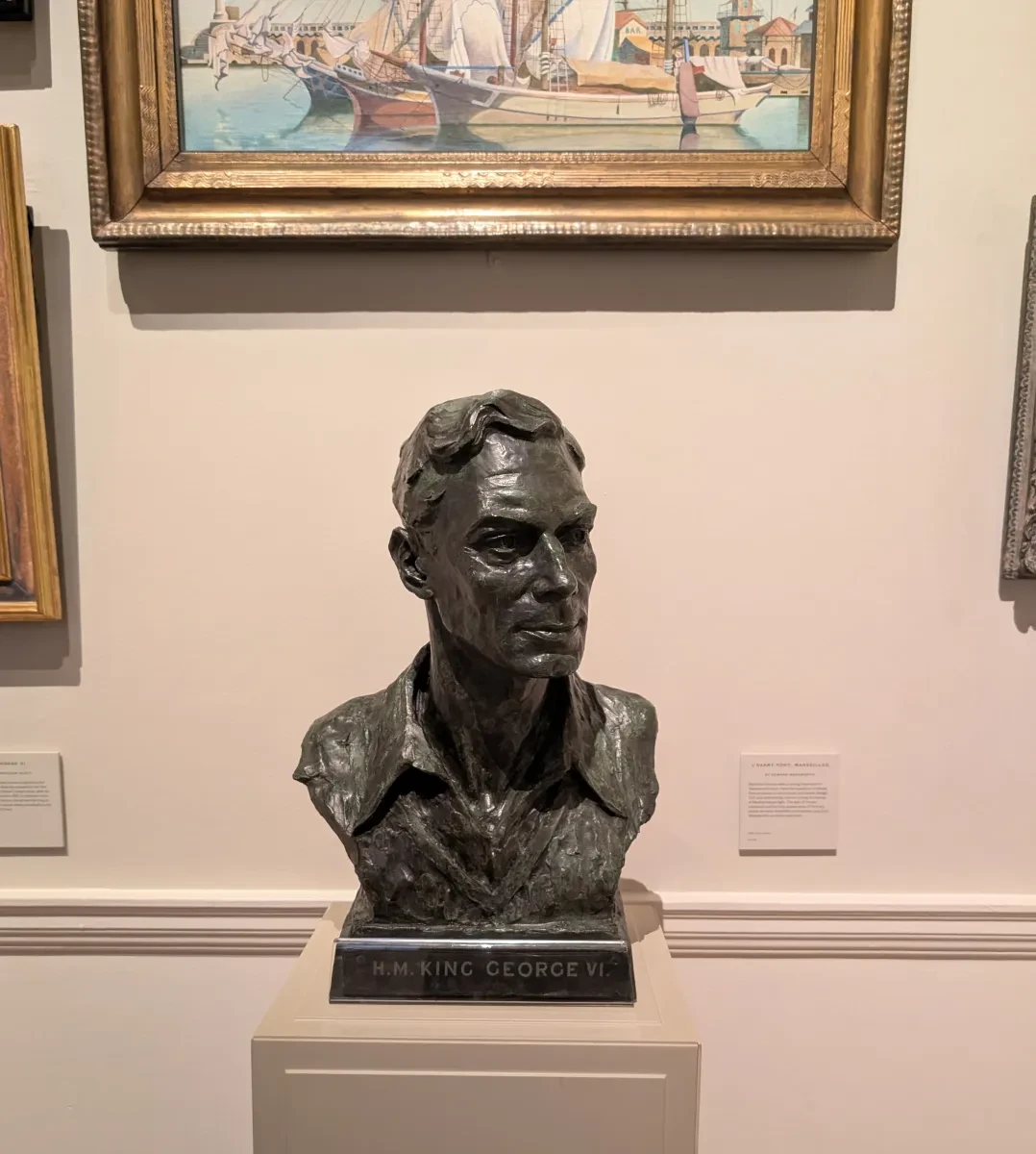 Bust of George VI wearing a V-neck jumper and open-necked shirt