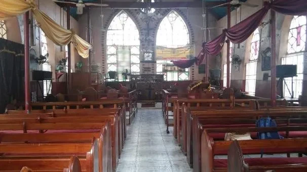 Photo of church with two large windows and a number of wooden pews