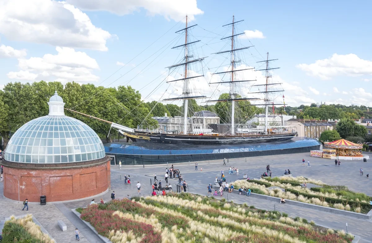 Wide angle view of Cutty Sark and the surrounding area, including the entrance to Greenwich Foot Tunnel