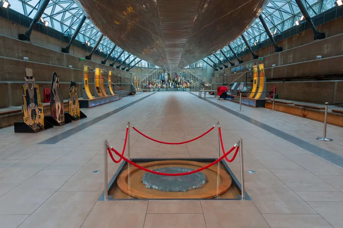 A metal and wood disc is cordoned off under the hull of Cutty Sark.