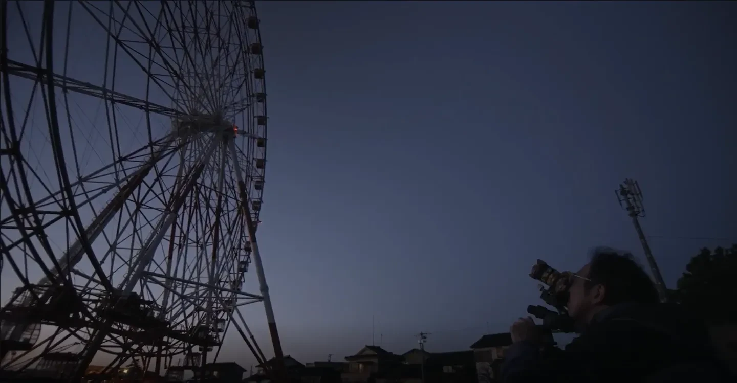 Takanobu Kurosaki photographing a Ferris wheel in semi darkness