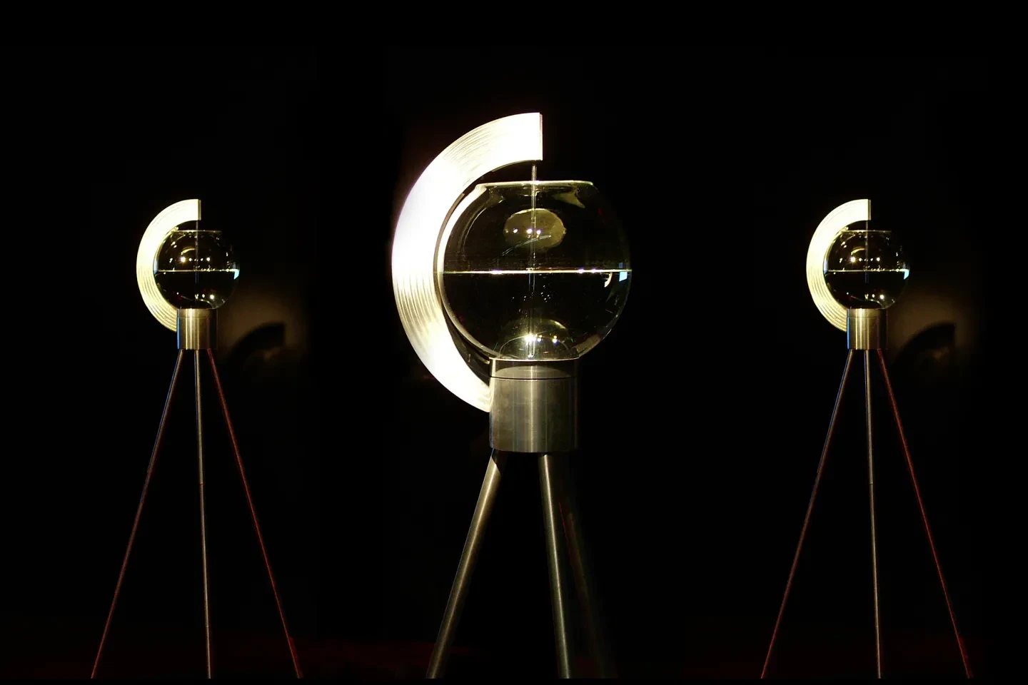 A sculpture consisting of a series of illuminated bowls on tripods