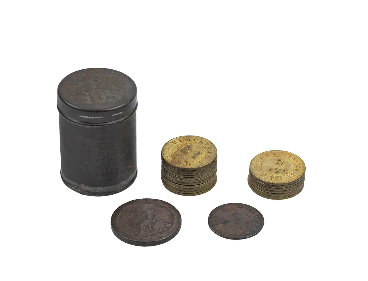 A metal coin tin placed next to two stacks of metal tokens and two coins