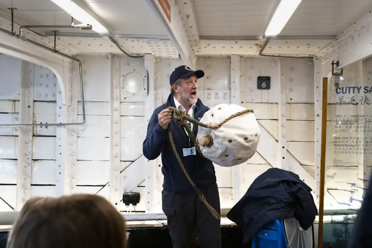 Volunteer giving talk holding life buoy on Cutty Sark